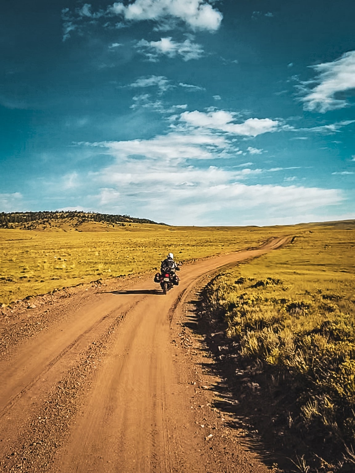 Piloto rodando por una terracería entre paisajes abiertos