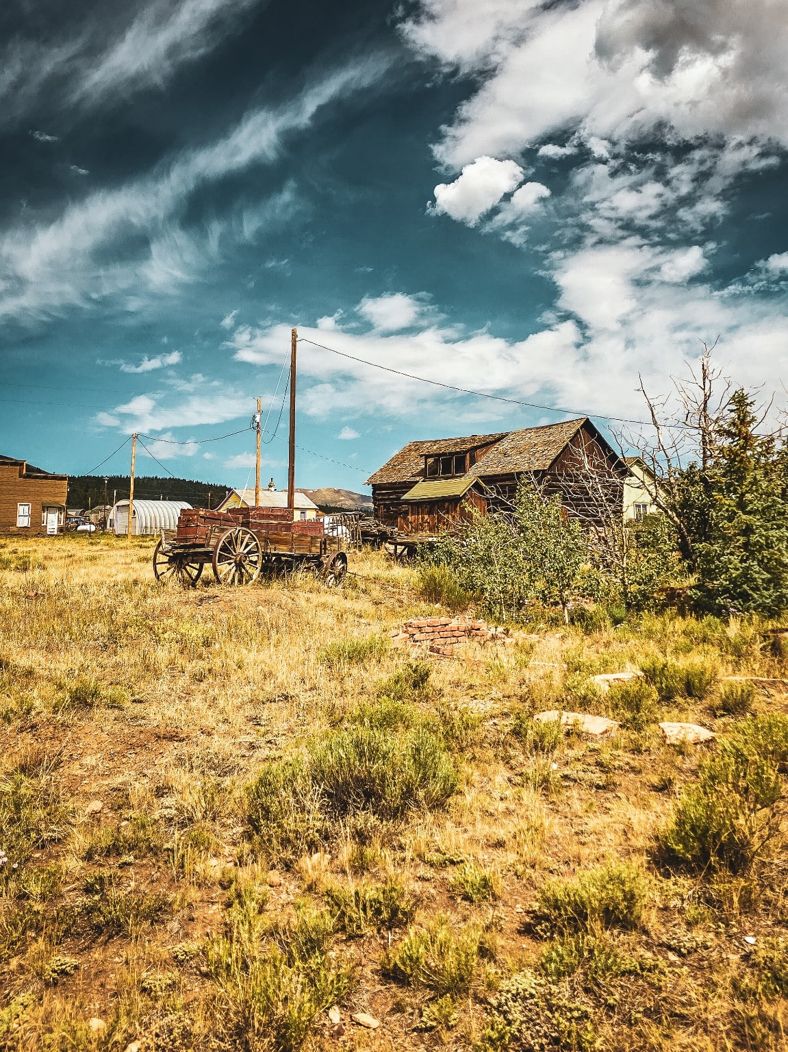 Construcciones de un rancho y carreta en un paisaje de montaña