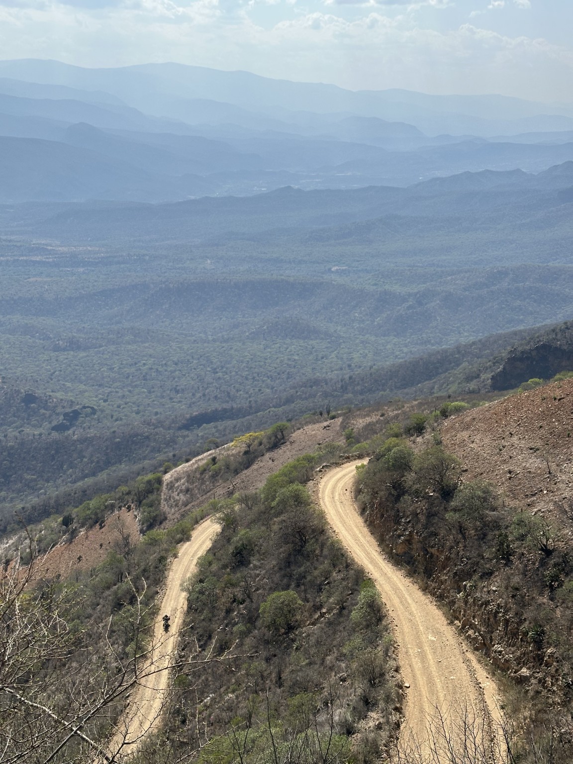 Camino de terracería con curvas entre laderas y montañas de Oaxaca